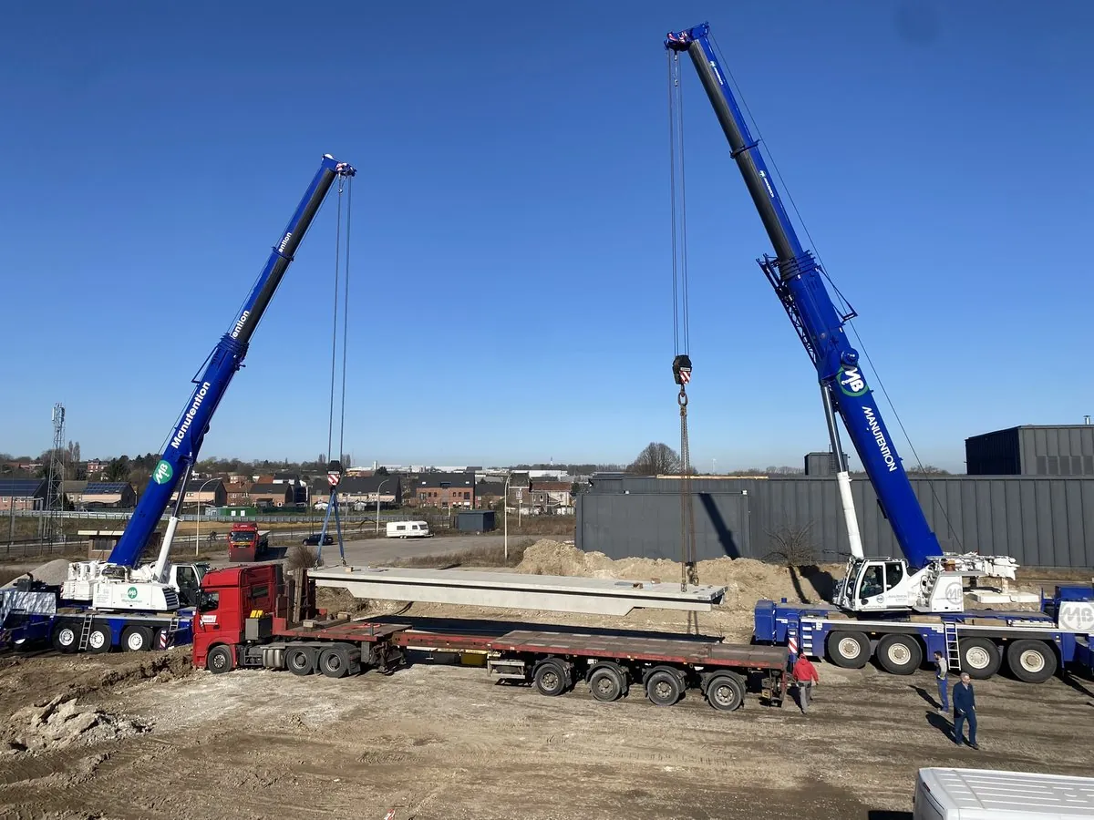 Pose d’un élément préfabriqué en béton pour un pont-bascule avec deux grues