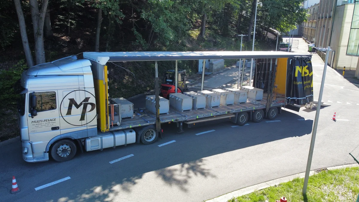 Sattelzug mit geöffneter Plane, Eichgewichten und Gabelstapler